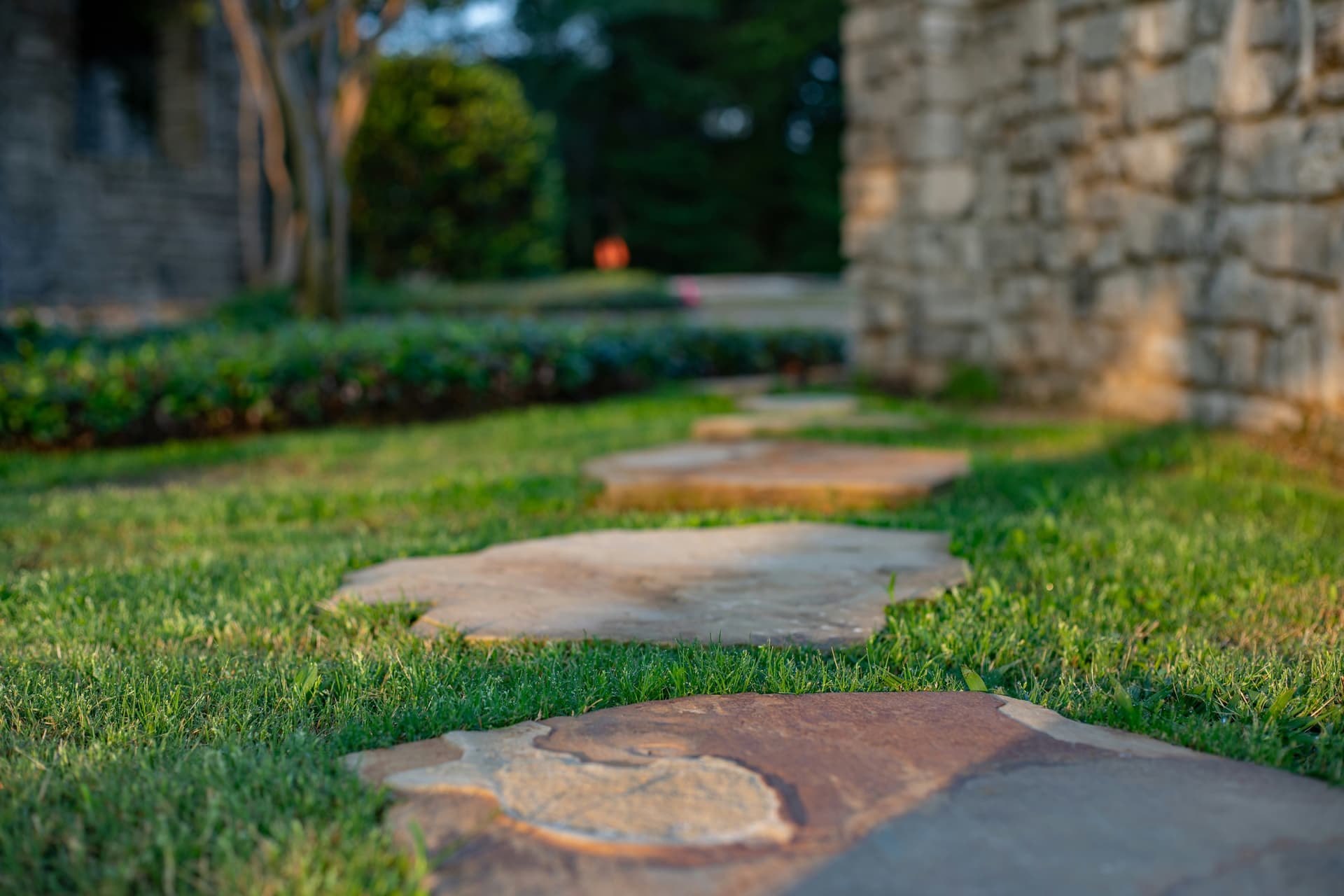 Stone steppers set into a level lawn beside garden planting
