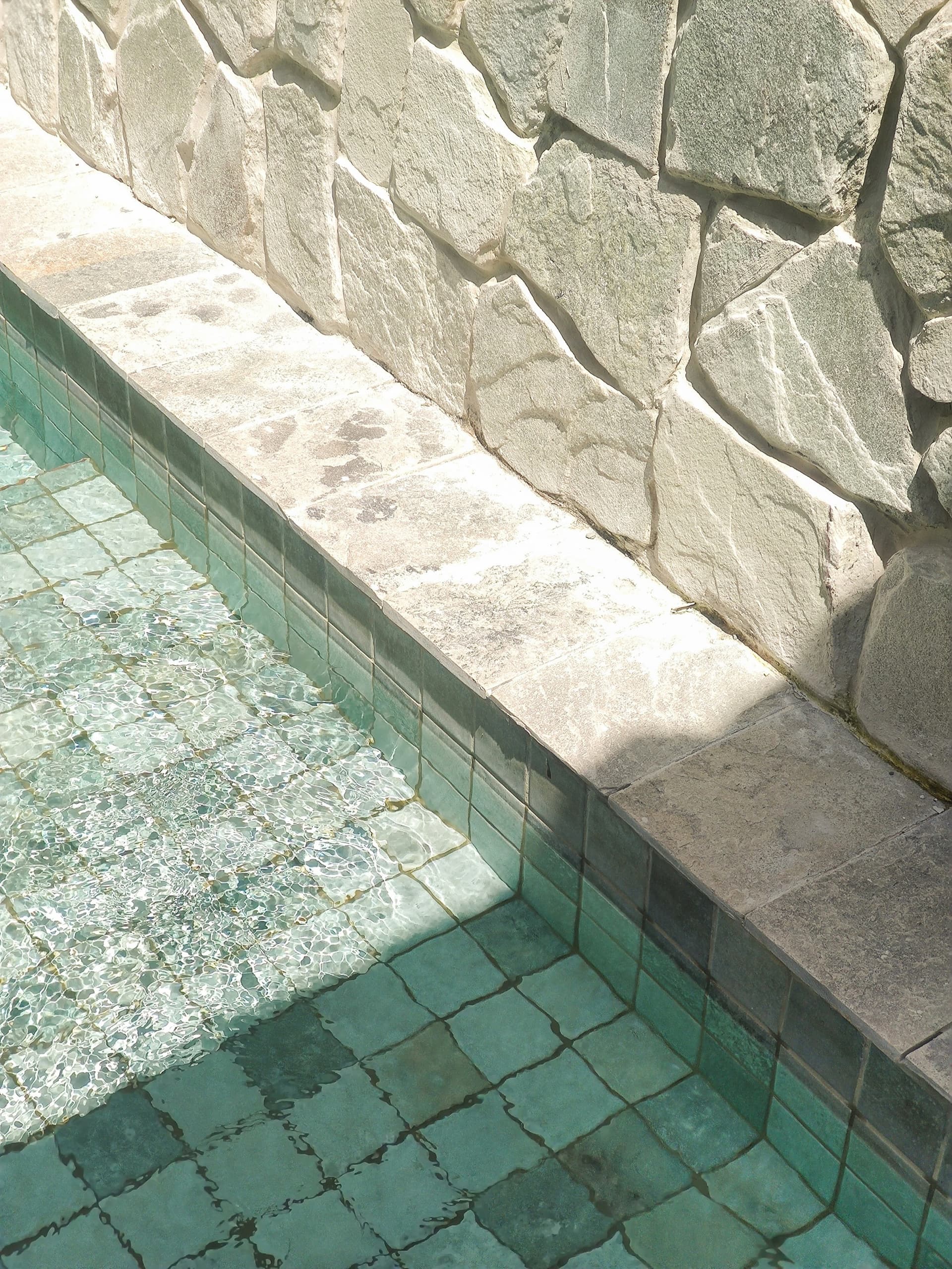 Stone coping and water detail at the edge of a designed pool