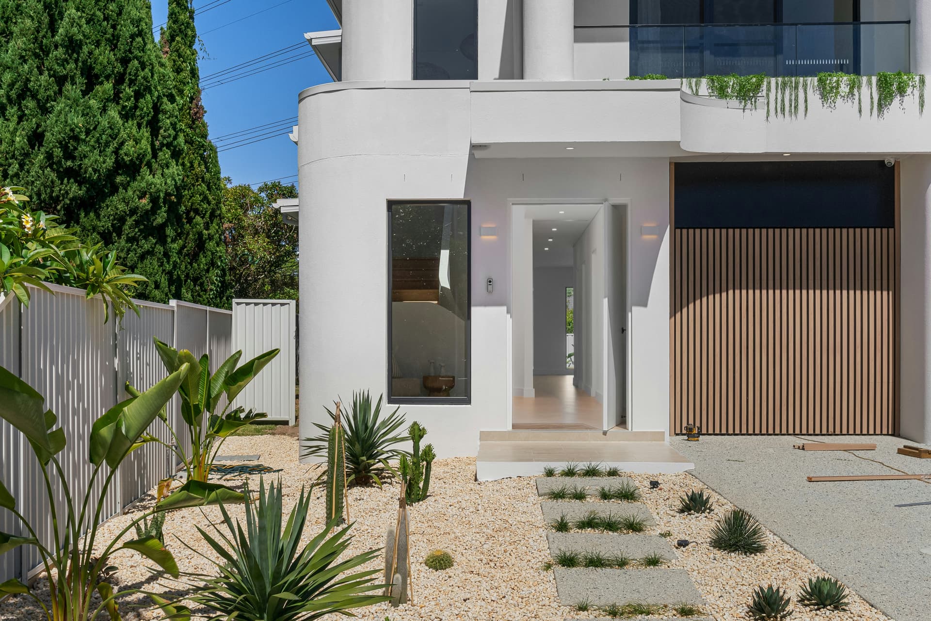 Compact, low-water designed front garden with gravel, agaves and stepping pavers at a modern Brisbane home